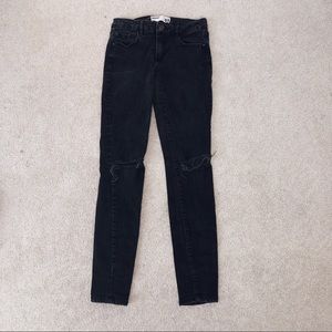 black skinny jeans with rips at both knees